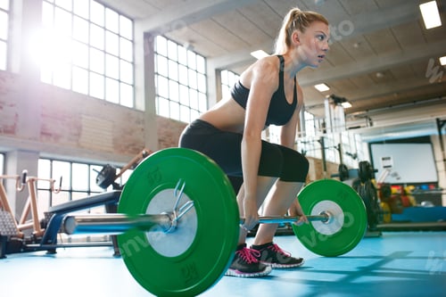 Preview: Woman in a gym doing heavy weight exercises