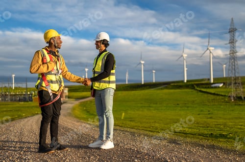 Preview: Wind turbine engineers shaking hands in a wind farm