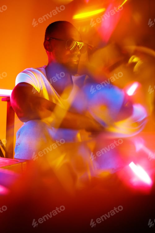 Vista previa: Cinematic portrait of handsome young man in neon lighted room, stylish musician