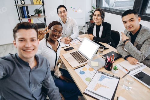 Preview: Multicultural group of professional business people making selfie in modern office