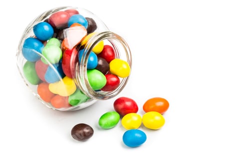 Preview: Transparent glass jar with colorful chocolate candies on white b