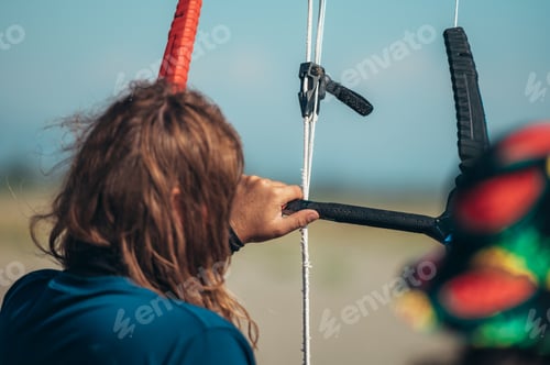 Preview: Man using flying lines and a control bar for kitesurfing