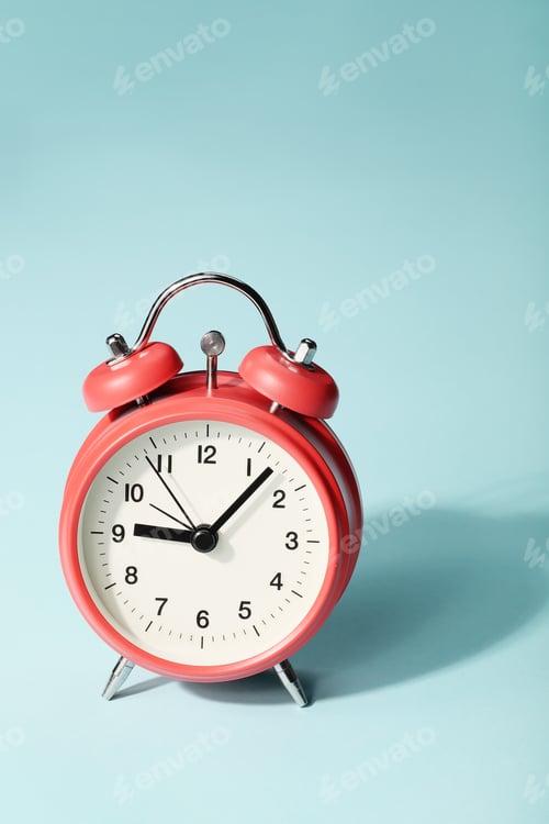 Preview: Red alarm clock with shadow on blue background. Seven minutes past nine on the clock