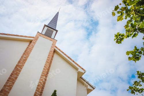 Preview: Building facade of a traditional American Protestant church with clock tower and blue sky.