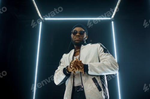 Preview: Stylish rapper in sunglasses, dark background