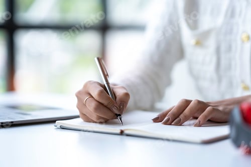 Preview: Cropped shot of Asian woman hand using laptop and writing making list taking notes in notepad workin