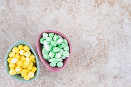Preview: Bowls with mint and lemon flavored candies on marble background