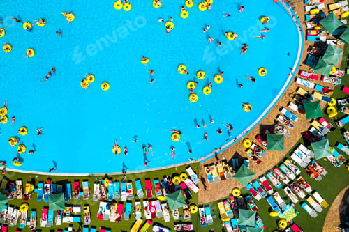 Preview: Top view of people relaxing in the pool on yellow inflatable circles and sun beds on the beach