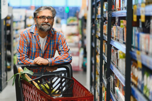 Preview: Handsome senior man shopping in a supermarket