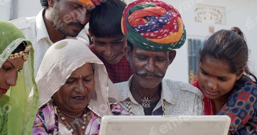Preview: Group of South Asian people in traditional Indian clothing using a laptop together