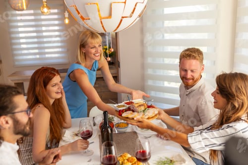 Preview: Woman bringing food to the table over Thanksgiving dinner