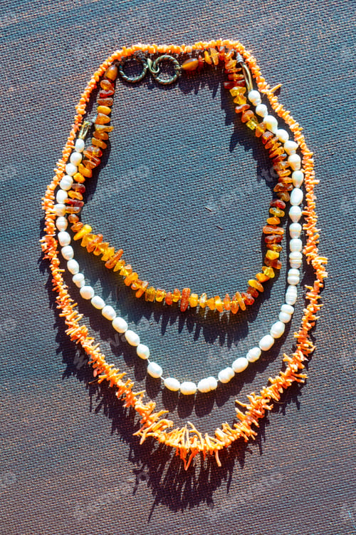 Preview: Coral amber pearl bright jewelry beads on a dark background.