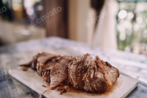 Preview: Pieces of roast beef lie in a row on a cutting board on the kitchen table