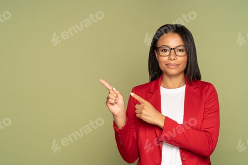 Preview: Confident african business woman in red jacket point finger to copy space demonstrate object product