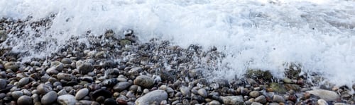 Preview: Web banner 4x1. Sea foam surf on a stone beach