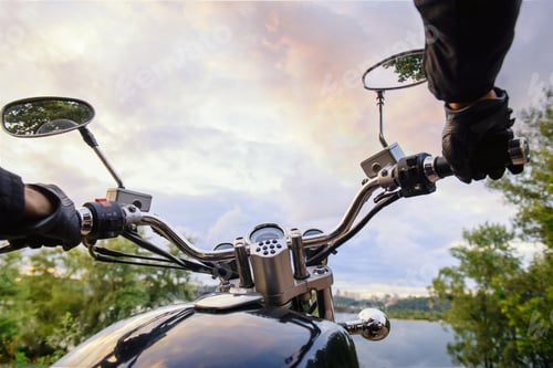 Preview: Biker driving a motorcycle on sunset. First-person view on handlebar and beautiful landscape