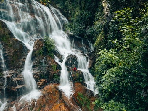 Preview: Aerial view of a beautiful waterfall in the middle of a forest in the pristine nature of the forest.