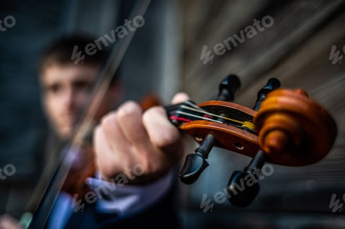 Preview: Closeup shot of a guy playing the violin in a blurred background