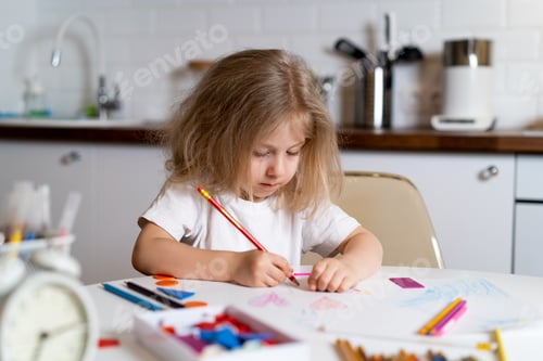 Preview: The little girl does homework at home in the kitchen, back to school
