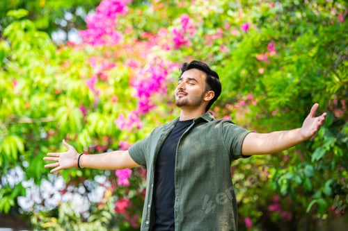 Preview: Freedom concept. Free Indian man with open arms on sunset admire nature view