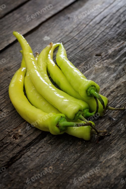 Preview: Stack of green chili peppers, on wooden surface
