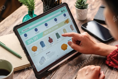 Preview: close up woman hand using credit card shopping online on mobile app on wood table at home