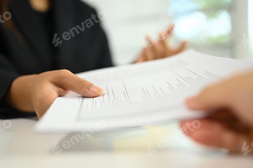 Preview: Unrecognizable businesswoman handing over a document to her colleague