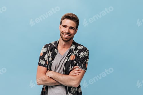 Preview: Wonderful young man with red beard in printed black shirt and grey cool t-shirt looking into camera