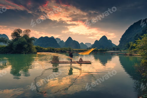 Preview: Beautiful scene of fisherman fishing on wooden raft, surrounded by mountain in the sunset