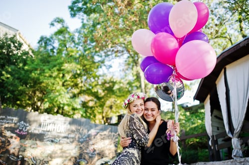 Preview: Two girls wear on black with balloons at hen party.