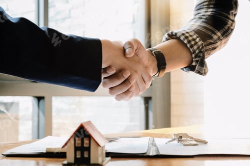 Preview: Real estate agent and customers shaking hands together celebrating finished contract after about