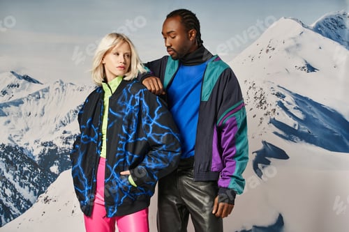 Preview: attractive multiracial couple in vibrant warm outfits with hand on shoulder, winter concept