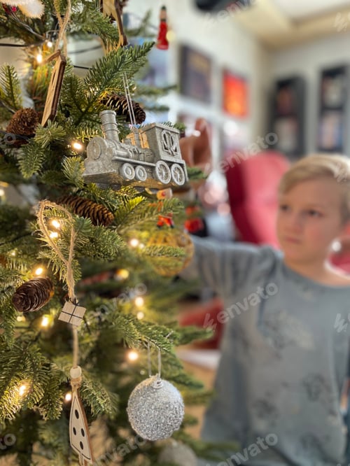 Preview: Child Decorating Christmas Tree with Ornaments at Home