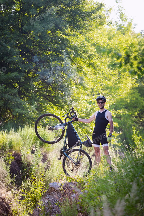 Preview: cyclist with bike on the street