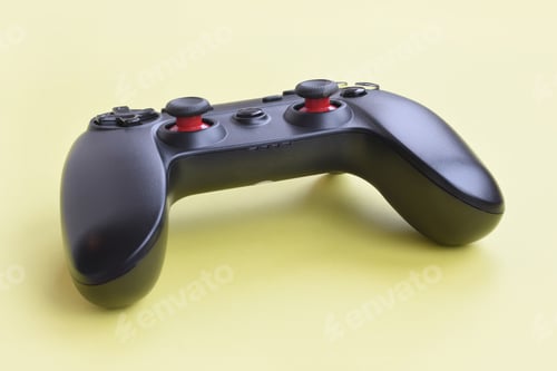 Preview: Modern black joystick on yellow background close up