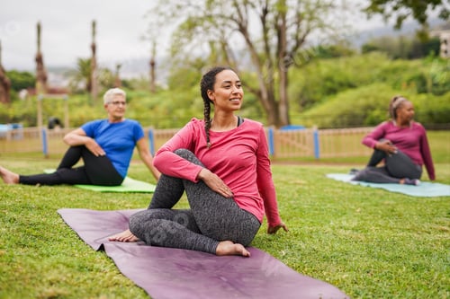 Preview: Group of multi generational women doing yoga exercise at park