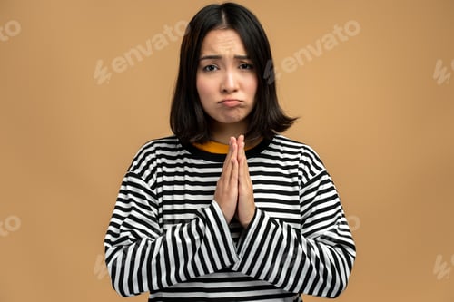 Preview: Upset worried woman looking with imploring desperate grimace and praying for help, asking apology