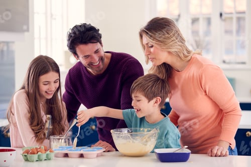 Preview: Family With Two Children In Kitchen At Home Having Fun Baking Cakes Together