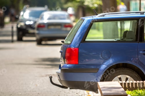 Preview: Blue car parked on sunny street, red stop lights, hook for dragging trailer, tow hitch or towbar.