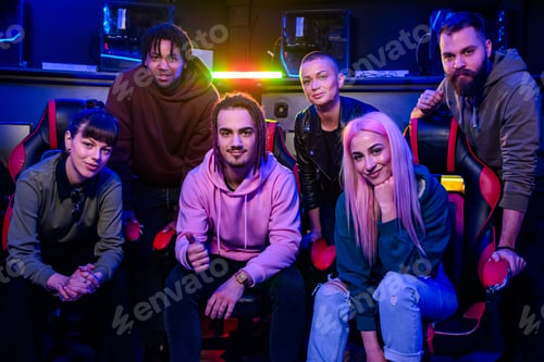 Preview: Professional esport gaming team sitting and standing in cybercafe.
