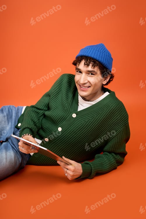 Preview: Stylish man posing playfully in vibrant colors, showcasing modern fashion trends and personality