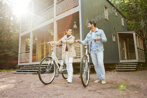 Aperçu: Jolly couple walking bicycles in countryside