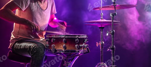 Preview: The drummer plays the drums. Beautiful blue and red background, with rays of light.