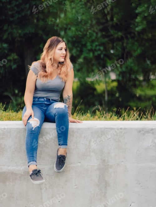 Preview: Woman Poses Outdoors Sitting on Concrete Wall