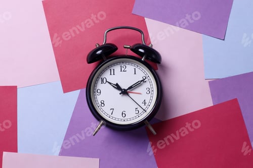 Preview: Black bell alarm clock on abstract multicolored papers background