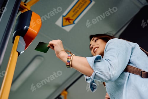 Preview: Below view of female passenger using electronic card while entering in public transport.