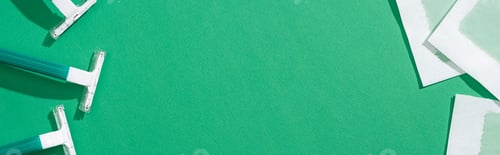 Preview: top view of green disposable razors and depilation wax stripes on green background with copy space,