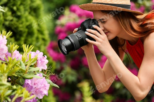 Preview: Photographer taking photo of blossoming bush with professional camera in park