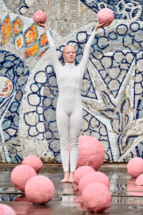 Preview: Outdoor dance of hairless girl ballerina with alopecia in white suit, holding two pink spheres