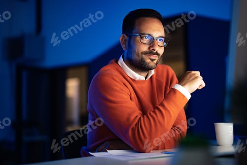 Ambitious man working alone at the office, using a computer, doing networking.